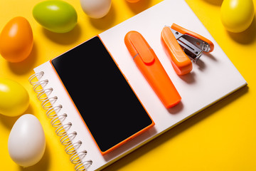 Smart phone and Easter decor on green background