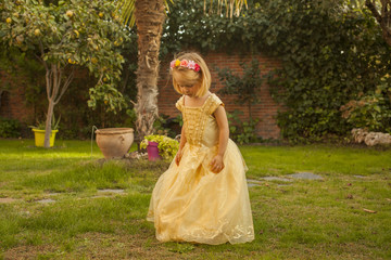 Obraz na płótnie Canvas Girl in a princess costume playing in the garden. Outdoors.