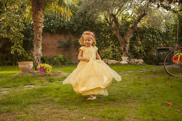 Fototapeta premium Girl in a princess costume playing in the garden. Outdoors.
