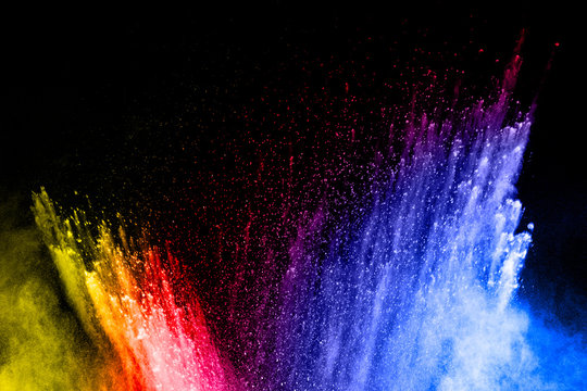 Abstract multicolored dust explosion on black background. Abstract color powder splattered  on dark background.