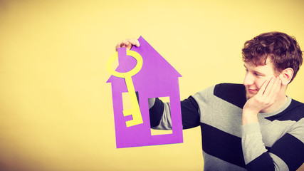 Man with paper house and key.