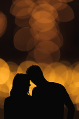 Silhouette of a couple with de-focused / bokeh lights.