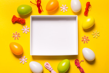 Empty box and Easter decor on yellow background