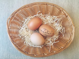 Handlettered eggs in a wicker basket for Easter celebration