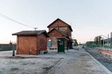 Old railroad station platform in countryside at sunset