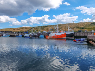 Fototapeta na wymiar Scottish fishing boats are resting in the harbor after hard early morning job 