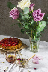 Dining table with flowers, herbal tea and strawberry pie, rustic style