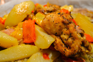 Potatoes with meat and vegetables baked in the oven on baking paper. Close-up