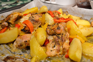 Potatoes with meat and vegetables baked in the oven on baking paper. Close-up