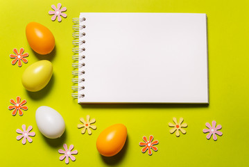 Blank notebook and Easter decor on green background