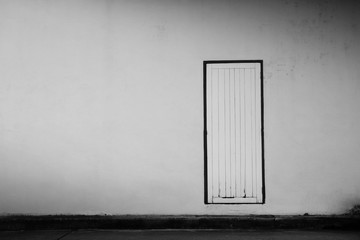 old wood door at concrete building - monochrome