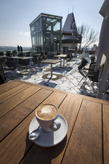 cup of coffee on schlossberg hill. In the background elevator and clocktower uhrturm on schlossberg...
