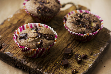 Homemade muffins with chocolate on an old wooden Board