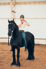 Handsome man in a shirt riding on a brown horse