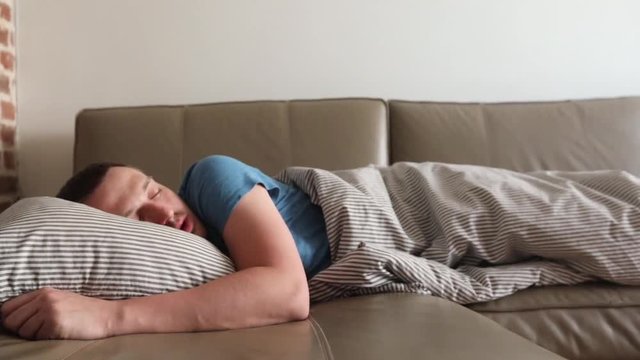 A man sleeps at home on a couch
