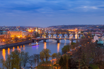 Obraz premium Old town and bridges over Vltava river illuminated night view from Letenske garden. Prague, Czech Republic