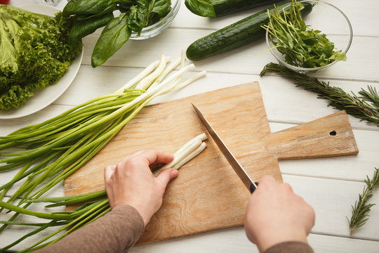 Woman cutting spring onion for salad