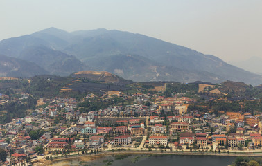 Sa Pa landscape with city, mountains, fog and trees the view from above from Sam Bay Cloud Yard in summer at Ham Rong Mountain Park in Sa Pa, Vietnam.