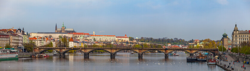 Wide panoramic view of Vltava river in Prague and Charles bridge and the Castle, Czech Republic