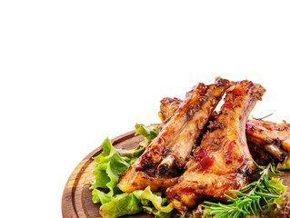 Fried pork ribs on a round wooden substrate with greens seasoning. Clipping path.