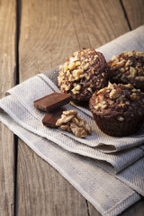 Homemade delicious chocolate Muffins with Walnut on wood backround