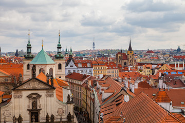 Fototapeta na wymiar View of old city roofs with The Church of St. Francis, Klementinum, Prague, Czech Republic
