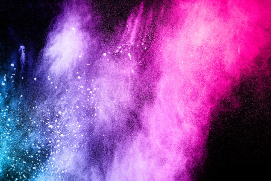 Multicolored powder explosion cloud isolated on black background. Freeze motion of color dust  particles splash.