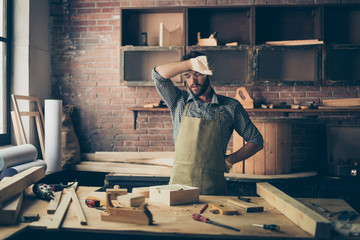 Tired exhausted weary overworked handsome bearded dressed in checkered shirt apron and gloves master of handmade crafts is wiping the sweat from his forehead, he is going to sell out his diy