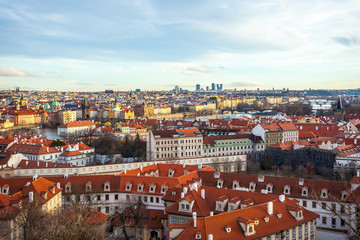 Fototapeta na wymiar View of Prague over houses with red roofs. Amazing view from above at old historical quarter. Prague, Czech Republic. Prague is famous and popular travel destination city