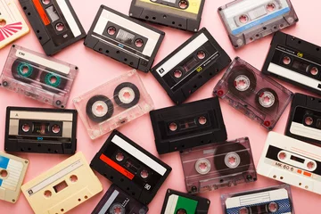 Poster Heap of vintage audio cassettes at pink background © Prostock-studio
