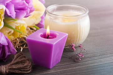 Fototapeta na wymiar Purple yellow tulips, lit candles