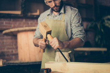 Cropped close up photo of serious confident hardworking joiner, he is working with chisel and...