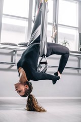 girl doing yoga, stretching on hammocks.