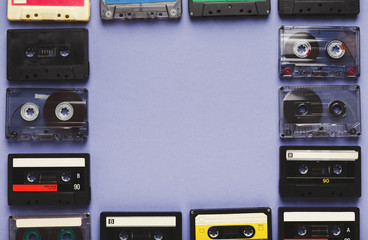 Vintage audio cassettes frame on violet background