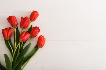 Colorful tulips on white wooden table with copy space