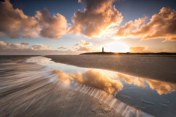 dramatic sunrise over North sea coast with lighthouse - obrazy, fototapety, plakaty