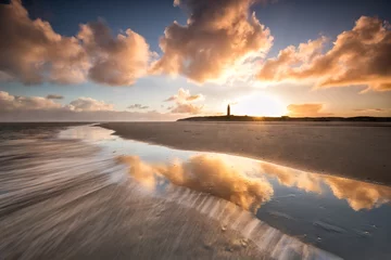 Zelfklevend Fotobehang dramatic sunrise over North sea coast with lighthouse © Olha Rohulya