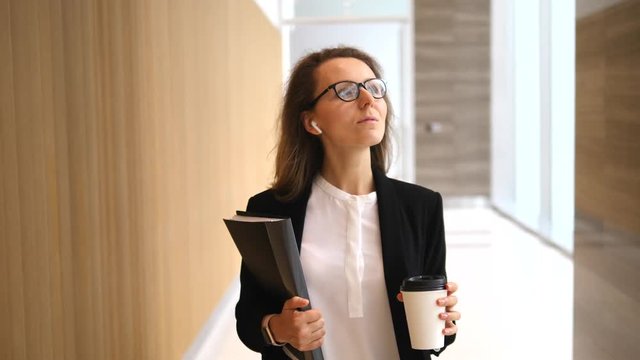 Confident Business Woman Walking With Coffee Indoors