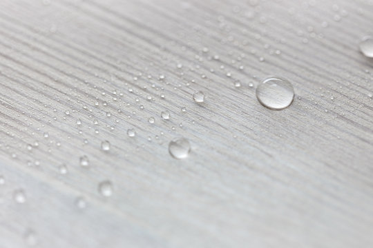Water drops on white wooden surface made from larch wood covering by oil with wax. - Powered by Adobe