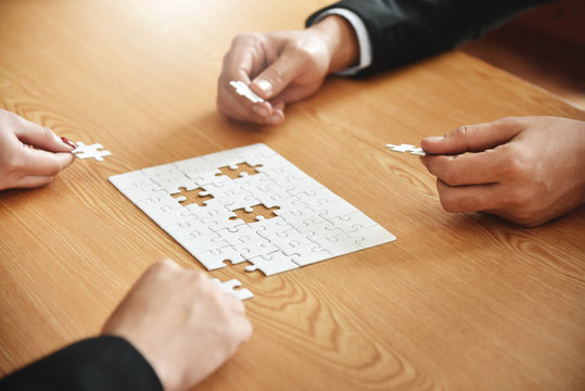 Business people hands are holding jigsaw puzzle.