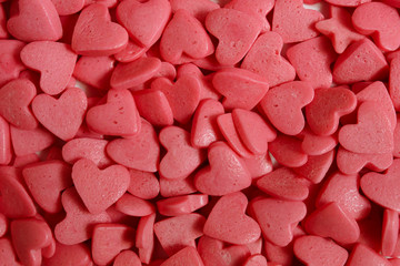 Sugar hearts for cake decoration. Confectionery decoration close-up. Pink hearts. Abstract background.