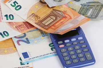 verschiedene Euroscheine liegen mit einem Taschenrechner im Studio