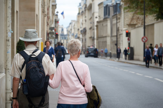 An adult couple of tourists walking through the streets of Paris