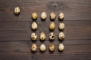 Quail eggs on dark wooden background. The view from the top. Copy spaсe