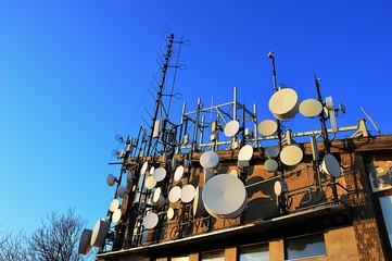 Telecommunication and microwave antennas and dishes installed on upper station of aricable. Evening...