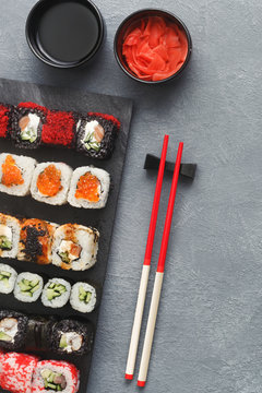 Set of sushi maki and rolls on grey background