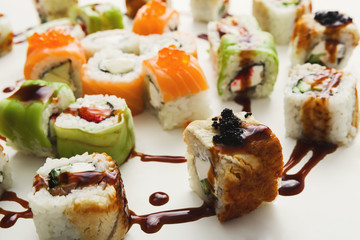 Set of sushi rolls, maki with unagi sauce on white