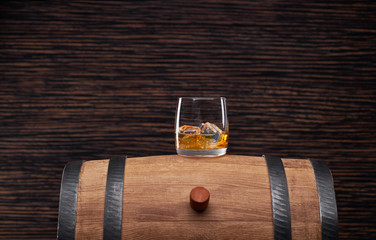 whiskey with ice on an old oak barrel