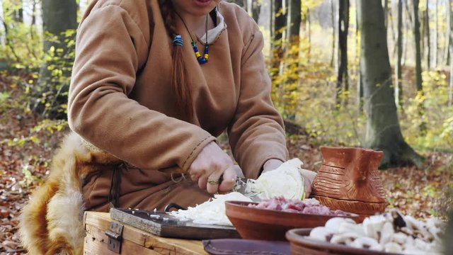 Womens viking are cooking in the forest camp. Womens talking and smiling