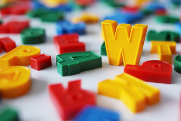 Letter W among the letters of the colorful alphabet on the magnet